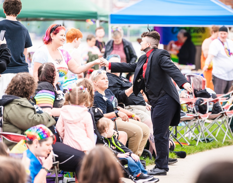 Logan Flynn Monroe accepts a tip at Quad Cities Pride Festival June 1