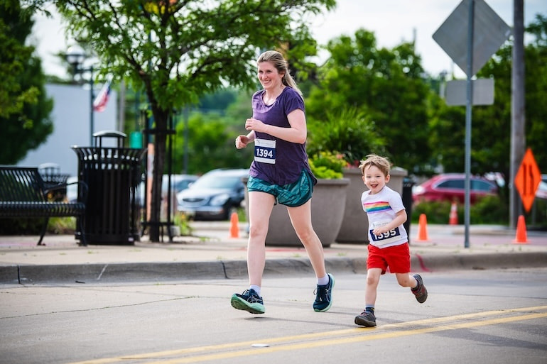 Mom and son smile while running during the Pride 5K in Moline June 15