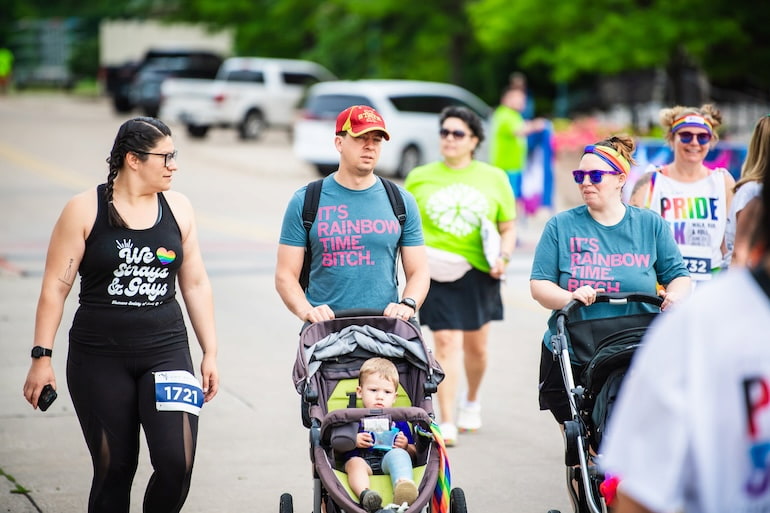 Families push strollers while walking in the Pride 5K Walk Run & Roll in Moline