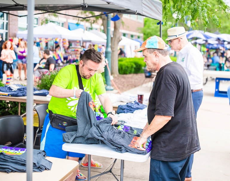 Tyler Mitchell at the booth for The Project of the Quad Cities during the Pride Party at Bass Street Landing June 15